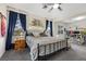 Bedroom features a queen bed, dark blue curtains, natural lighting and extra seating area at 2717 Cool Lilac Ave, Henderson, NV 89052