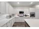 Spacious modern kitchen with white cabinets, quartz countertops, stainless appliances and island at 2717 Cool Lilac Ave, Henderson, NV 89052