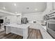 Modern kitchen featuring white cabinets, stainless steel appliances, a center island, and wood floors at 2717 Cool Lilac Ave, Henderson, NV 89052