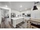 The kitchen has white cabinets, stainless steel appliances, a center island, and wood floors at 2717 Cool Lilac Ave, Henderson, NV 89052