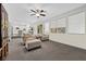 Bright living room featuring plush seating, a ceiling fan, and natural light from the large windows with views at 2717 Cool Lilac Ave, Henderson, NV 89052