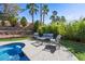 A serene poolside seating area surrounded by tropical landscaping for ultimate relaxation and privacy at 2717 Cool Lilac Ave, Henderson, NV 89052