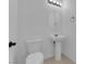 Clean half bathroom with pedestal sink, toilet, and modern lighting at 311 Lilian Faith Ave, North Las Vegas, NV 89031