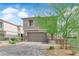 Charming two-story home featuring a well-manicured yard and a two-car garage on a beautiful, sunny day at 311 Lilian Faith Ave, North Las Vegas, NV 89031