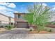 Charming two-story home featuring a well-manicured yard and a two-car garage on a beautiful, sunny day at 311 Lilian Faith Ave, North Las Vegas, NV 89031