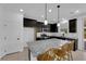 Bright kitchen featuring a granite countertop island, tile backsplash, and wooden chairs at 311 Lilian Faith Ave, North Las Vegas, NV 89031