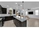 Open-concept kitchen with granite island and seating that flows into the living area at 311 Lilian Faith Ave, North Las Vegas, NV 89031