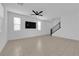 Well-lit living space featuring tile flooring, modern ceiling fan, contemporary design, and staircase to the upper level at 311 Lilian Faith Ave, North Las Vegas, NV 89031