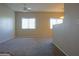 Bright living room featuring neutral carpeting, two windows, and a ceiling fan for comfort at 3400 Cabana Dr # 2010, Las Vegas, NV 89122