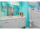 Vibrant bathroom featuring a large mirror, white vanity, tub with shower, and eye-catching turquoise walls at 3550 Bay Sands Dr # 1003, Laughlin, NV 89029