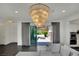 Stylish living room featuring chic chandelier lighting and backyard patio with stone fireplace and dining area at 362 Port Reggio St, Las Vegas, NV 89138