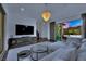 Bright living room with large TV, chandelier lighting, and sliding glass doors to the outdoor space at 362 Port Reggio St, Las Vegas, NV 89138