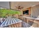 A covered outdoor kitchen with bar seating, a built-in grill, and ample counter space at 362 Port Reggio St, Las Vegas, NV 89138