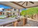 Outdoor kitchen with bar seating and built-in appliances overlooking a pool and landscaped backyard at 362 Port Reggio St, Las Vegas, NV 89138