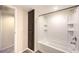 Bright bathroom featuring a tub with a shower head, and a built in shelf, along with a tall cabinet for extra storage at 3683 Villa Knolls East Dr, Las Vegas, NV 89120