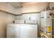 Bright laundry room with washer, dryer, water heater and storage shelves at 3683 Villa Knolls East Dr, Las Vegas, NV 89120