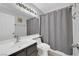 Neutral bathroom featuring a shower with gray curtain, a modern sink, and a vanity light at 3905 Blairmoor St, North Las Vegas, NV 89032