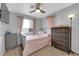 Cozy bedroom featuring a ceiling fan, plush bedding, and a matching dresser and nightstand at 3905 Blairmoor St, North Las Vegas, NV 89032