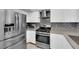 Modern kitchen featuring stainless steel appliances, gray countertops, and a stylish backsplash at 3905 Blairmoor St, North Las Vegas, NV 89032