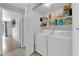 Efficient laundry room with washer, dryer, and ample storage shelves with cleaning supplies at 3905 Blairmoor St, North Las Vegas, NV 89032
