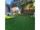 Spacious backyard with artificial grass, mature tree, and block wall fencing, perfect for outdoor living at 4075 E Oquendo Rd, Las Vegas, NV 89120