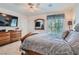 Bedroom with a wooden sleigh bed, ceiling fan, and a dresser topped with a television at 4075 E Oquendo Rd, Las Vegas, NV 89120