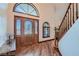 Elegant foyer featuring hardwood floors, decorative front door with sidelights, and staircase at 4075 E Oquendo Rd, Las Vegas, NV 89120