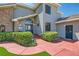 Welcoming front entrance with a brick facade, blue door, and green shrubbery at 4075 E Oquendo Rd, Las Vegas, NV 89120