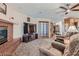 Relaxing living room with brick fireplace, TV, and comfortable armchairs at 4075 E Oquendo Rd, Las Vegas, NV 89120