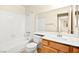 Bathroom with a tub, tiled walls, wooden cabinets, and a sink with a wide mirror at 433 Old Palms Dr, Las Vegas, NV 89123