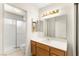 Well-lit bathroom featuring a shower, toilet, and a wooden vanity with double mirrors and modern fixtures at 433 Old Palms Dr, Las Vegas, NV 89123