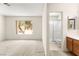 Bright bedroom featuring a large window with outside views and an attached bathroom with a walk-in shower at 433 Old Palms Dr, Las Vegas, NV 89123