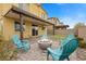 Cozy backyard featuring a fire pit surrounded by blue Adirondack chairs and covered patio at 4519 Stardusk Falls Ave, North Las Vegas, NV 89084