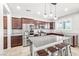 Beautiful kitchen with dark wood cabinets, granite countertops, stainless steel appliances, and a central island at 4519 Stardusk Falls Ave, North Las Vegas, NV 89084