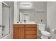 Bright bathroom with wooden vanity, white countertop, and shower with glass door at 50 Aura De Blanco St # 18204, Henderson, NV 89074