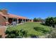 Spacious backyard boasts a large grassy area, mature trees, and covered patio seating at 5725 N Durango Dr, Las Vegas, NV 89149