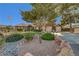 Beautiful home with a well-manicured front yard, mature trees, and rock landscaping at 5725 N Durango Dr, Las Vegas, NV 89149