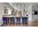 Kitchen island with granite counters and seating overlooks the sink and stainless steel appliances at 5725 N Durango Dr, Las Vegas, NV 89149
