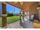 Inviting covered patio with ceiling fan overlooks a well-maintained lawn and mature landscaping at 5725 N Durango Dr, Las Vegas, NV 89149