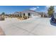 Wide driveway leading to a three-car garage, complemented by rock landscaping at 60 N Fogg St, Las Vegas, NV 89110