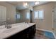 Bathroom featuring a double sink vanity, shower, wood-look tile floors, and a window with plantation shutters at 6403 Brandon Hills Ct, Las Vegas, NV 89139