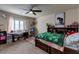 Bright and airy bedroom features a queen-sized bed, desk, and ceiling fan at 6403 Brandon Hills Ct, Las Vegas, NV 89139