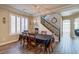 Elegant dining room with modern chandelier, wood-look flooring, and adjacent staircase, perfect for gatherings at 6403 Brandon Hills Ct, Las Vegas, NV 89139