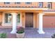 Charming home entrance with decorative columns, a barrel planter, and an ornate wrought iron front door at 6403 Brandon Hills Ct, Las Vegas, NV 89139