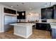 Modern kitchen with a large island, stainless appliances, and stylish dark wood cabinetry at 6403 Brandon Hills Ct, Las Vegas, NV 89139