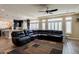 Open-concept living area with leather sectional, connects to kitchen and offers ample natural light at 6403 Brandon Hills Ct, Las Vegas, NV 89139