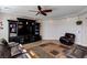 Cozy living room featuring a leather sectional, media center, and stylish wood-look flooring at 6403 Brandon Hills Ct, Las Vegas, NV 89139