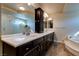 A double sink vanity, dark cabinetry, and a separate tub and shower highlight this main bathroom at 6403 Brandon Hills Ct, Las Vegas, NV 89139