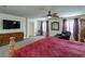 This carpeted main bedroom includes a ceiling fan and flatscreen television over a dresser at 6403 Brandon Hills Ct, Las Vegas, NV 89139