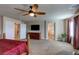 The carpeted main bedroom boasts a ceiling fan, doors to other rooms, and flatscreen TV at 6403 Brandon Hills Ct, Las Vegas, NV 89139
